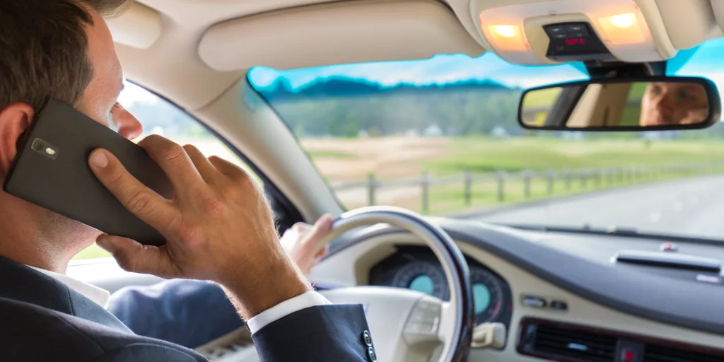 man talking on his cell phone while driving needs digital decluttering