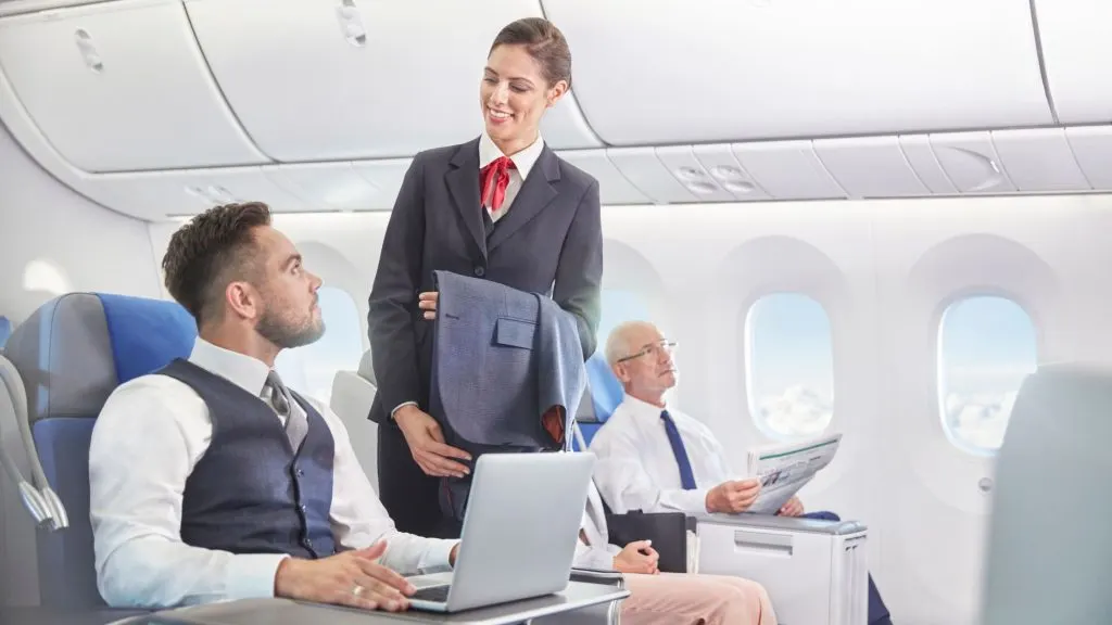 An image of a man asking a flight attendant for drinks.