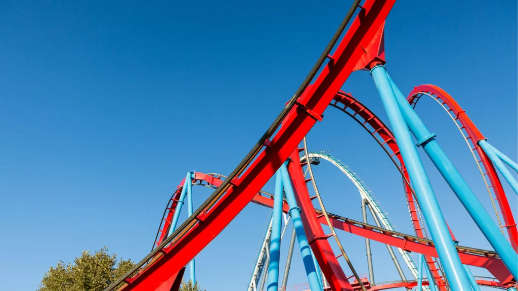 An image of a red and blue rails of a roller coaster.