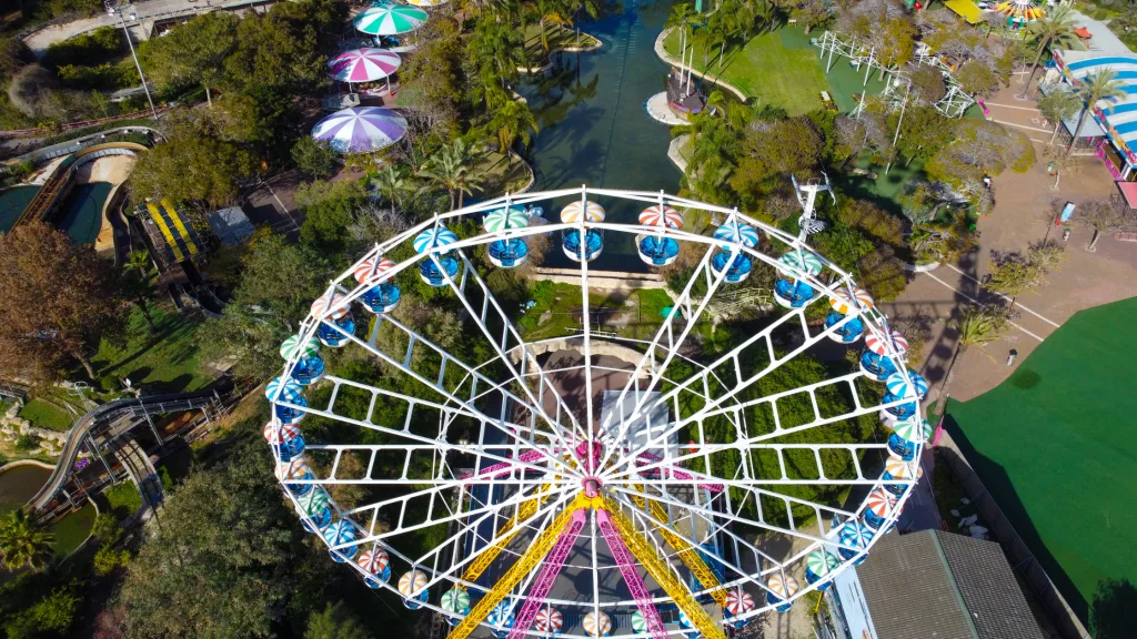 An aerial shot of a ferris wheel in one of the best amusement parks for kids.