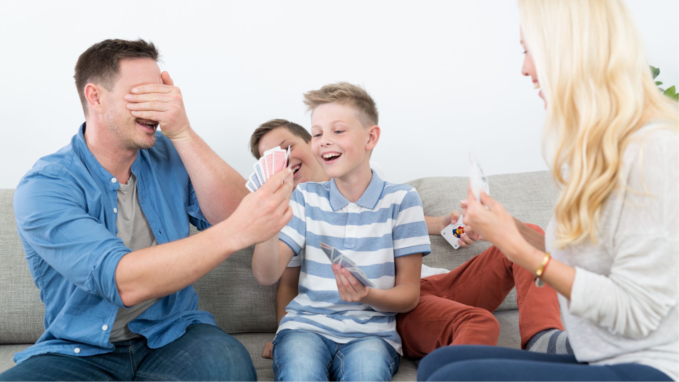 An image of a family playing a card game for an article about "fun games to play with family."