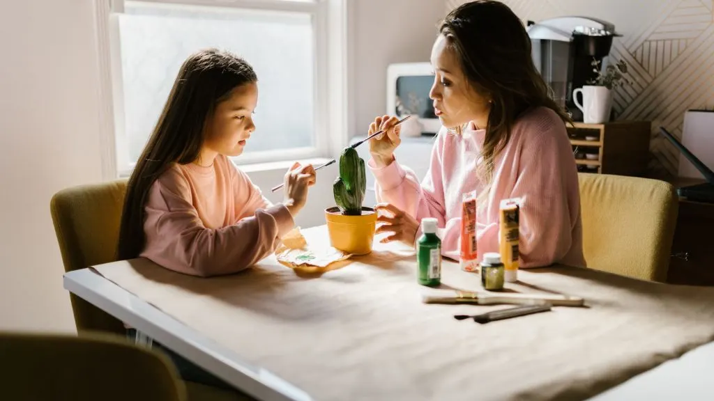 An image of a mother and daughter painting a cactus.