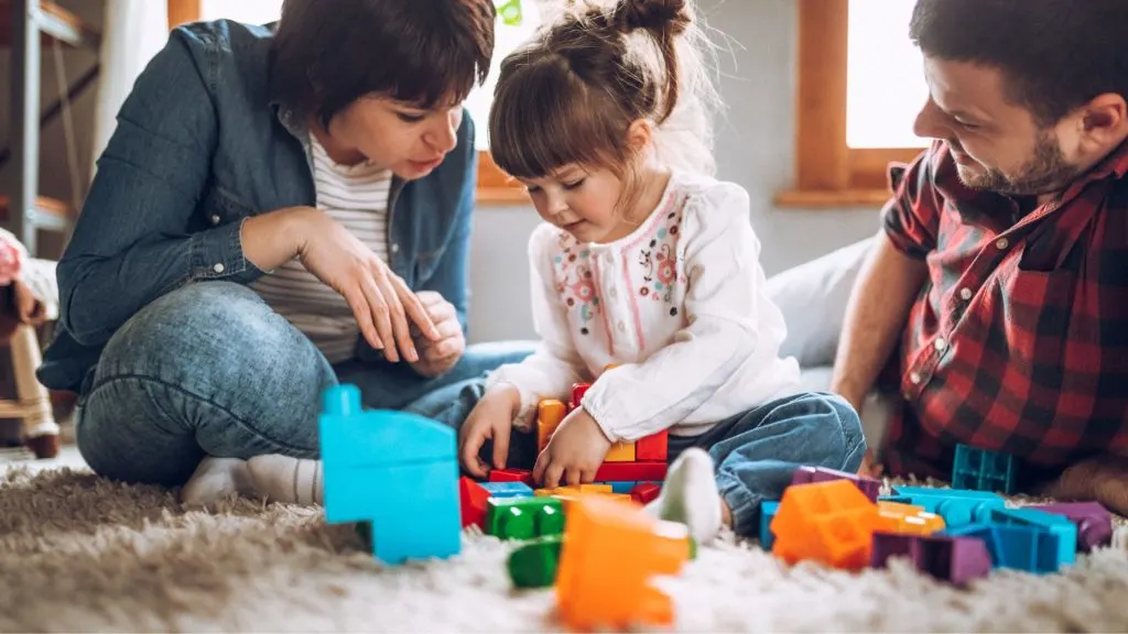 An image of parents and their kid playing together.