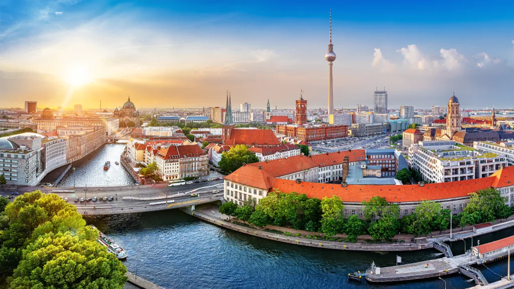 An aerial picture of Berlin, Germany with a rising sun in the background.