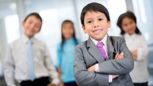 An image of children in business suits for an article about "small business ideas for kids."