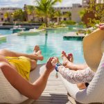 An image of two vacationers on lounge chairs for an article about Airbnb luxury rental.