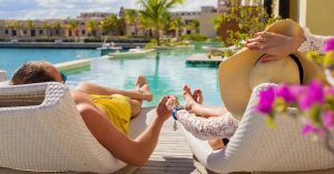 An image of two vacationers on lounge chairs for an article about Airbnb luxury rental.