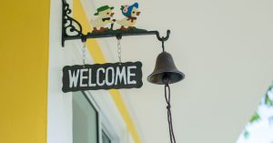 an image of a welcome sign hanged with a windchime