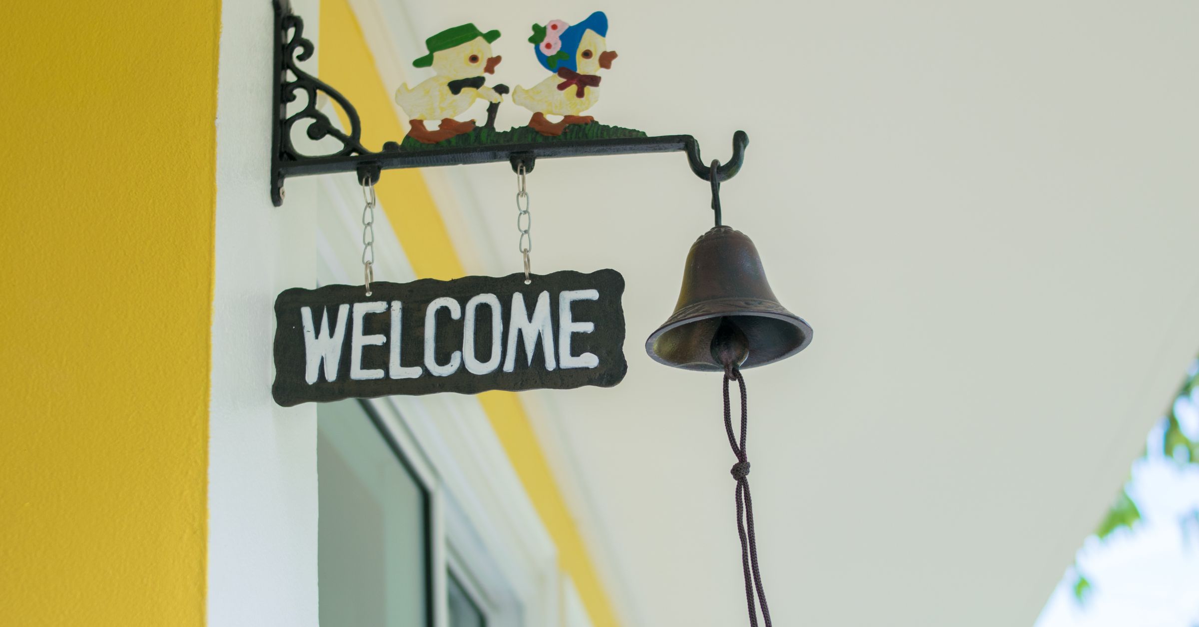 an image of a welcome sign hanged with a windchime