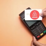 An image of a host making a payment for an article about "how much does Airbnb take."