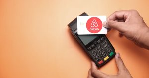 An image of a host making a payment for an article about "how much does Airbnb take."
