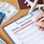An image of a traveler signing an insurance form for an article about the best travel insurance.