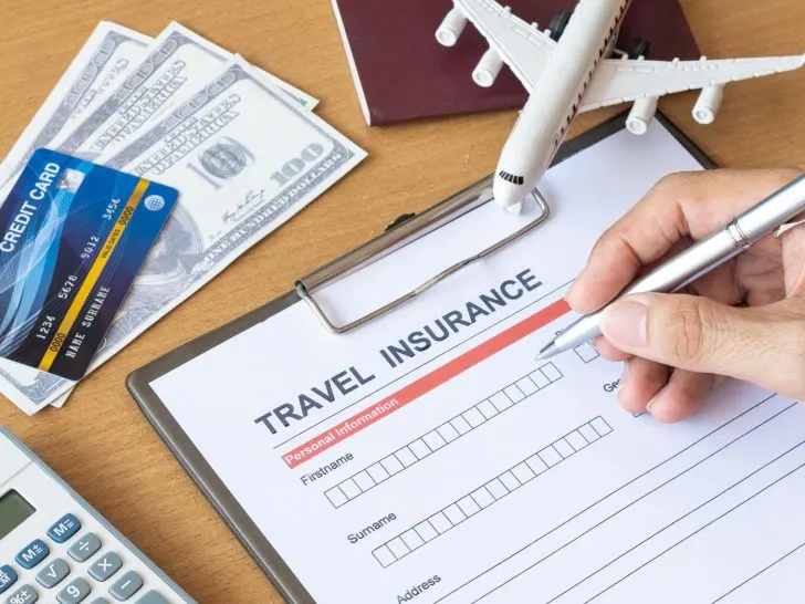 An image of a traveler signing an insurance form for an article about the best travel insurance.