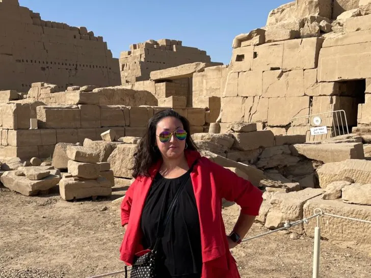 A woman stands confidently in front of ancient ruins, symbolizing reflection and resilience. This image illustrates the importance of grounding yourself in history and action when grappling with an existential crisis. #HowToOvercomeExistentialCrisis