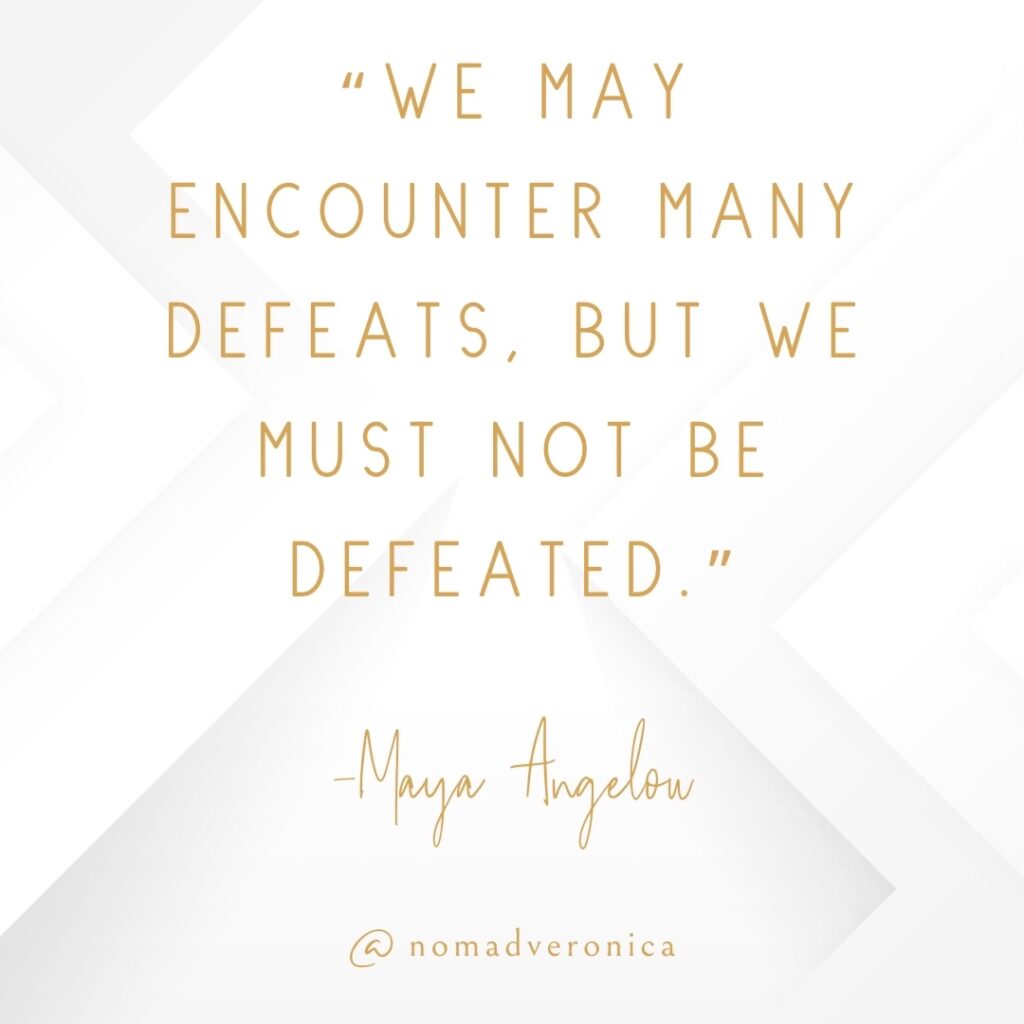 A motivational quote by Maya Angelou reads, "We may encounter many defeats, but we must not be defeated," displayed in elegant gold text on a minimalist white background with subtle geometric accents. The design is signed "@nomadveronica," adding a polished and personal touch.