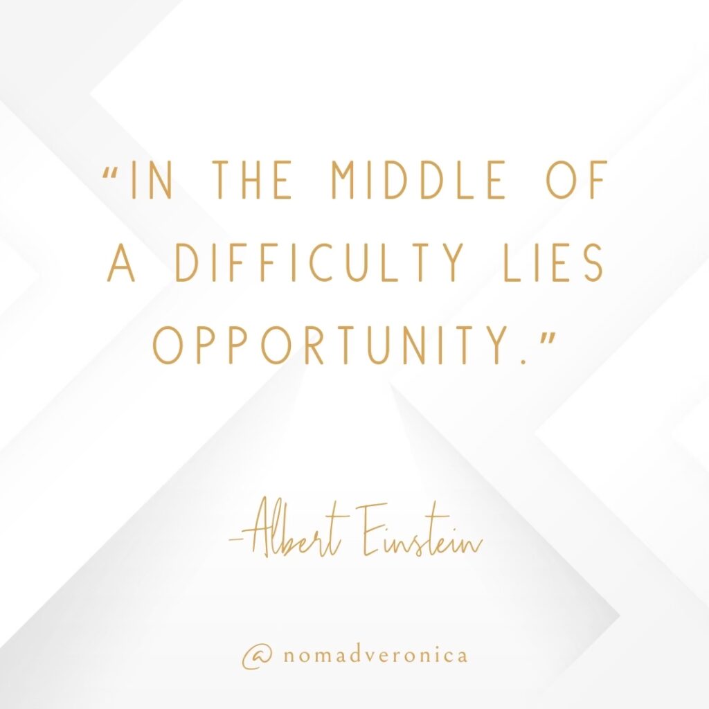 A motivational quote by Albert Einstein reads, "In the middle of a difficulty lies opportunity," presented in gold lettering on a clean, white background featuring understated geometric patterns. The design is tagged "@nomadveronica," lending it a refined, personalized feel.