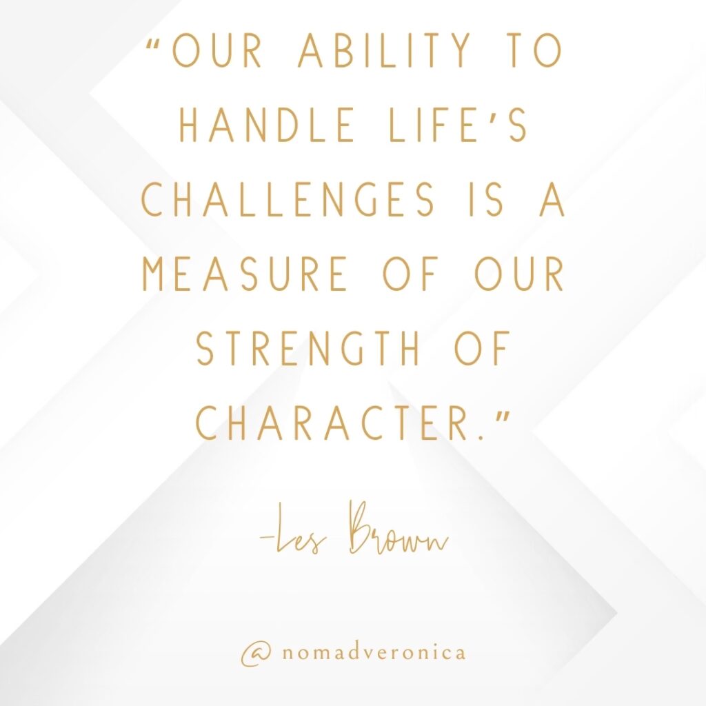 Inspirational quote graphic with the text: "Our ability to handle life's challenges is a measure of our strength of character." - Les Brown. The background features a soft white geometric design, and the Instagram handle @nomadveronica is displayed at the bottom in a minimalist gold font. Perfect for a blog section on uplifting quotes about overcoming challenges.