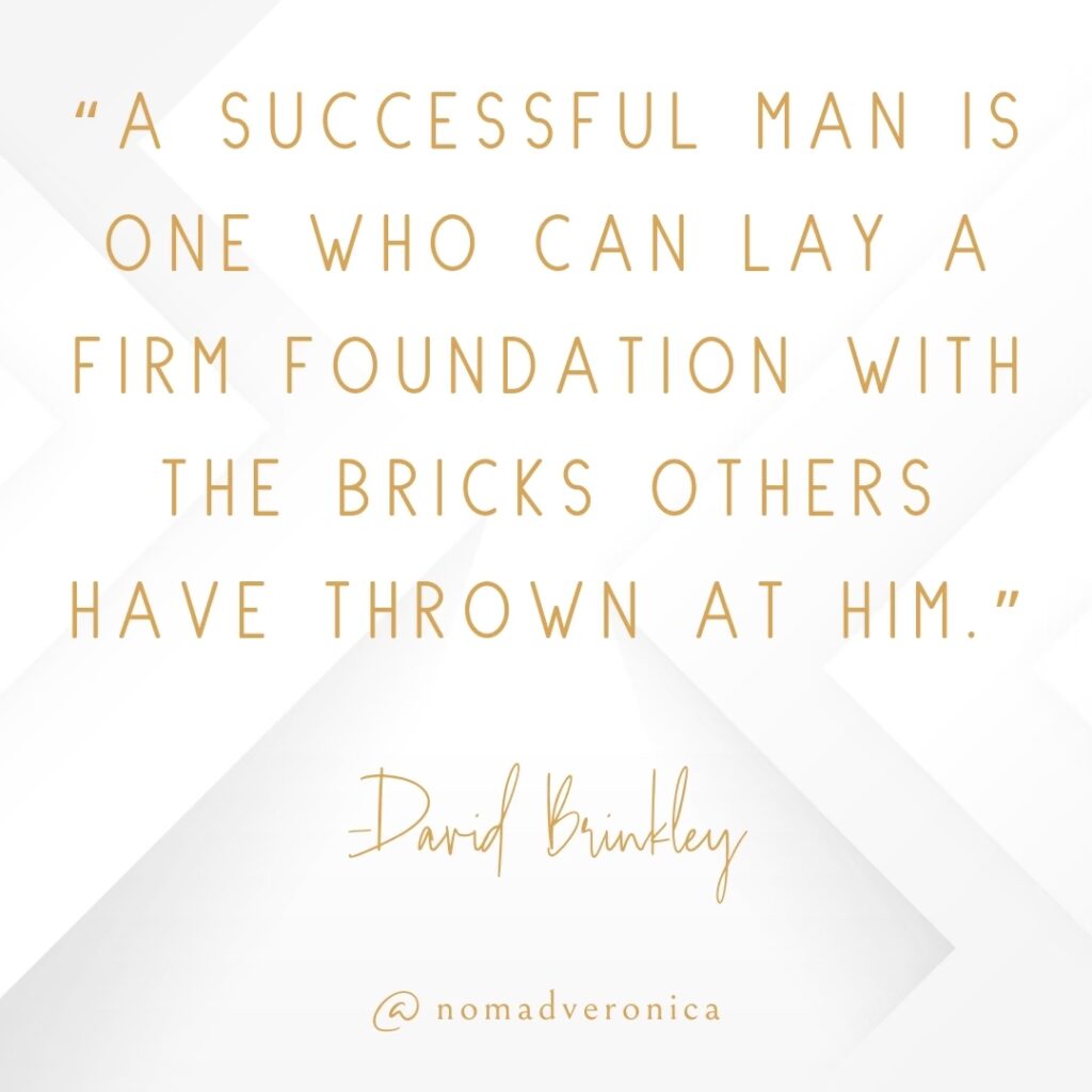 A motivational quote by David Brinkley says, "A successful man is one who can lay a firm foundation with the bricks others have thrown at him," elegantly written in gold on a white background with geometric accents. The branding "@nomadveronica" is included at the bottom, adding a personal touch to the design.