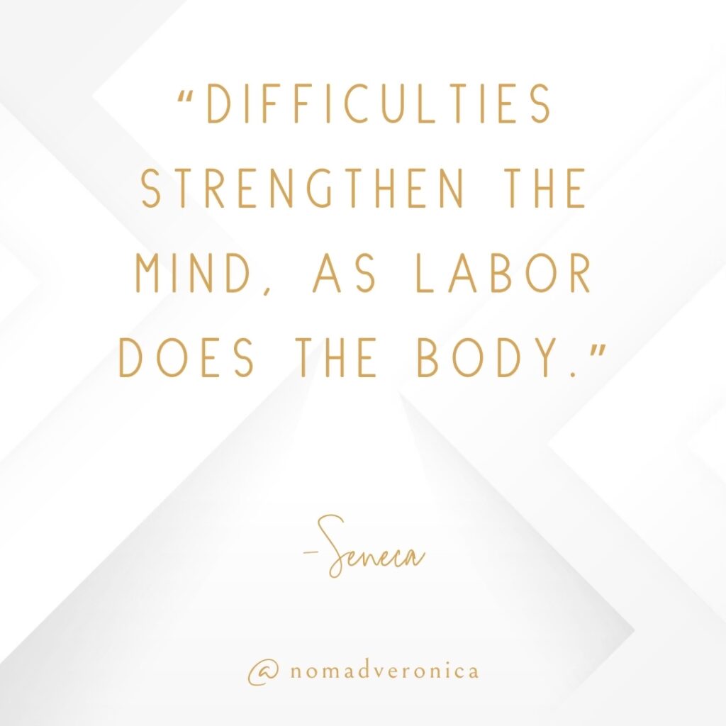 A motivational quote by Seneca, "Difficulties strengthen the mind, as labor does the body," is presented in gold text on a minimalist white background with subtle geometric patterns. The quote is signed "@nomadveronica" at the bottom, adding an elegant touch to the design.