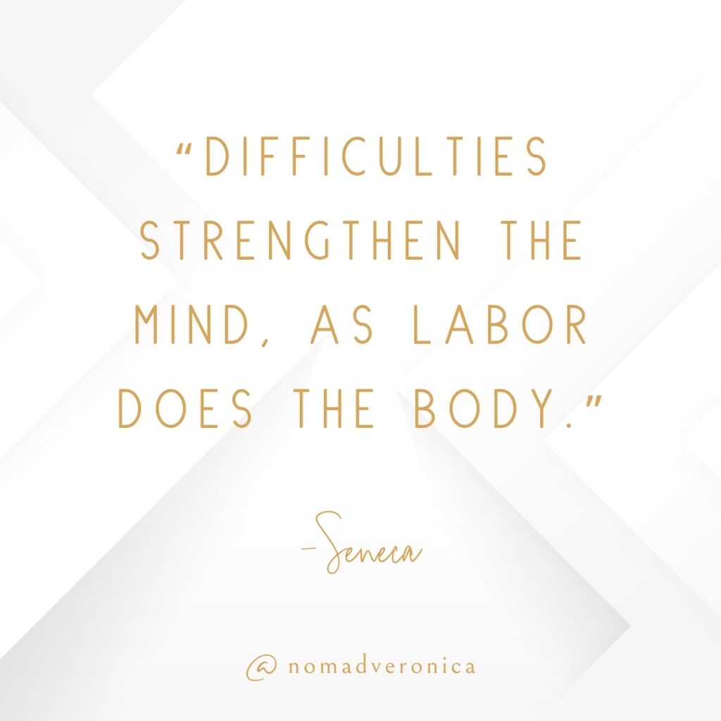 White and gold minimalist graphic displaying the quote 'Difficulties strengthen the mind, as labor does the body' by Seneca, attributed to @nomadveronica. A motivational choice for a section on quotes about embracing new challenges.