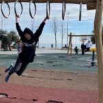 Children playing on a wooden playground near a waterfront in Istanbul, showcasing a family-friendly environment. Perfect for families looking for places to stay in Istanbul with access to outdoor activities and scenic views.
