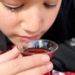 Close-up of a child enjoying traditional Turkish tea in a tulip-shaped glass, reflecting Istanbul's vibrant culture and culinary offerings found at the best restaurants in Istanbul.