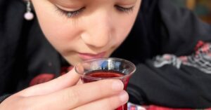 Close-up of a child enjoying traditional Turkish tea in a tulip-shaped glass, reflecting Istanbul's vibrant culture and culinary offerings found at the best restaurants in Istanbul.