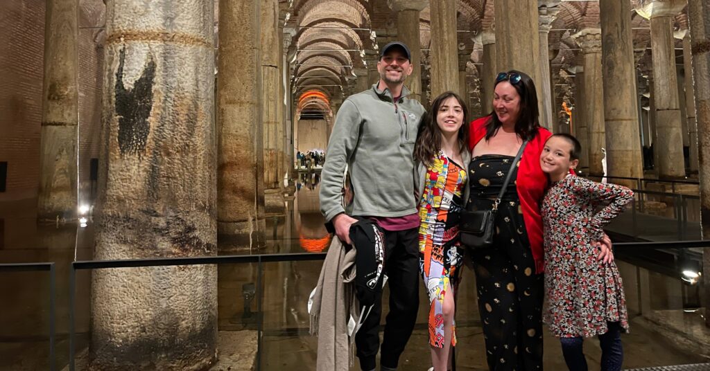 A family enjoying the historical Basilica Cistern in Istanbul, an underground marvel with illuminated columns, perfect for learning and exploring unique things to do in Istanbul, Turkey.