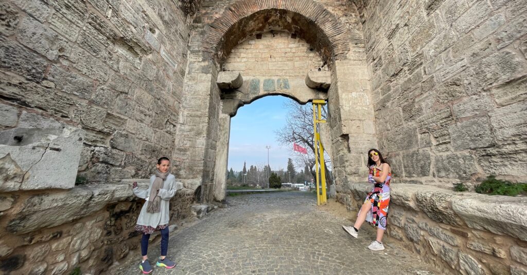 Two children standing at the historic Wall of Constantinople in Istanbul, exploring ancient architecture and one of the top historical things to do in Istanbul, Turkey, with kids."