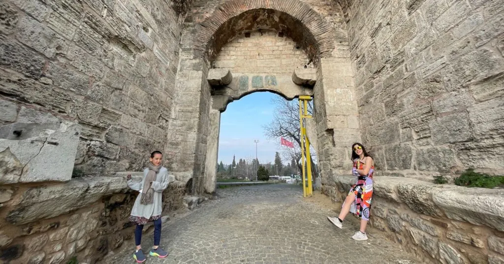 Two children standing at the historic Wall of Constantinople in Istanbul, exploring ancient architecture and one of the top historical things to do in Istanbul, Turkey, with kids."