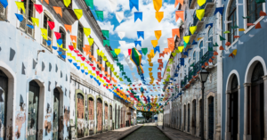 A lively street lined with colonial buildings, adorned with multicolored banners. Experiencing Brazil’s festivals and traditions is a highlight for those moving to Brazil from the US.