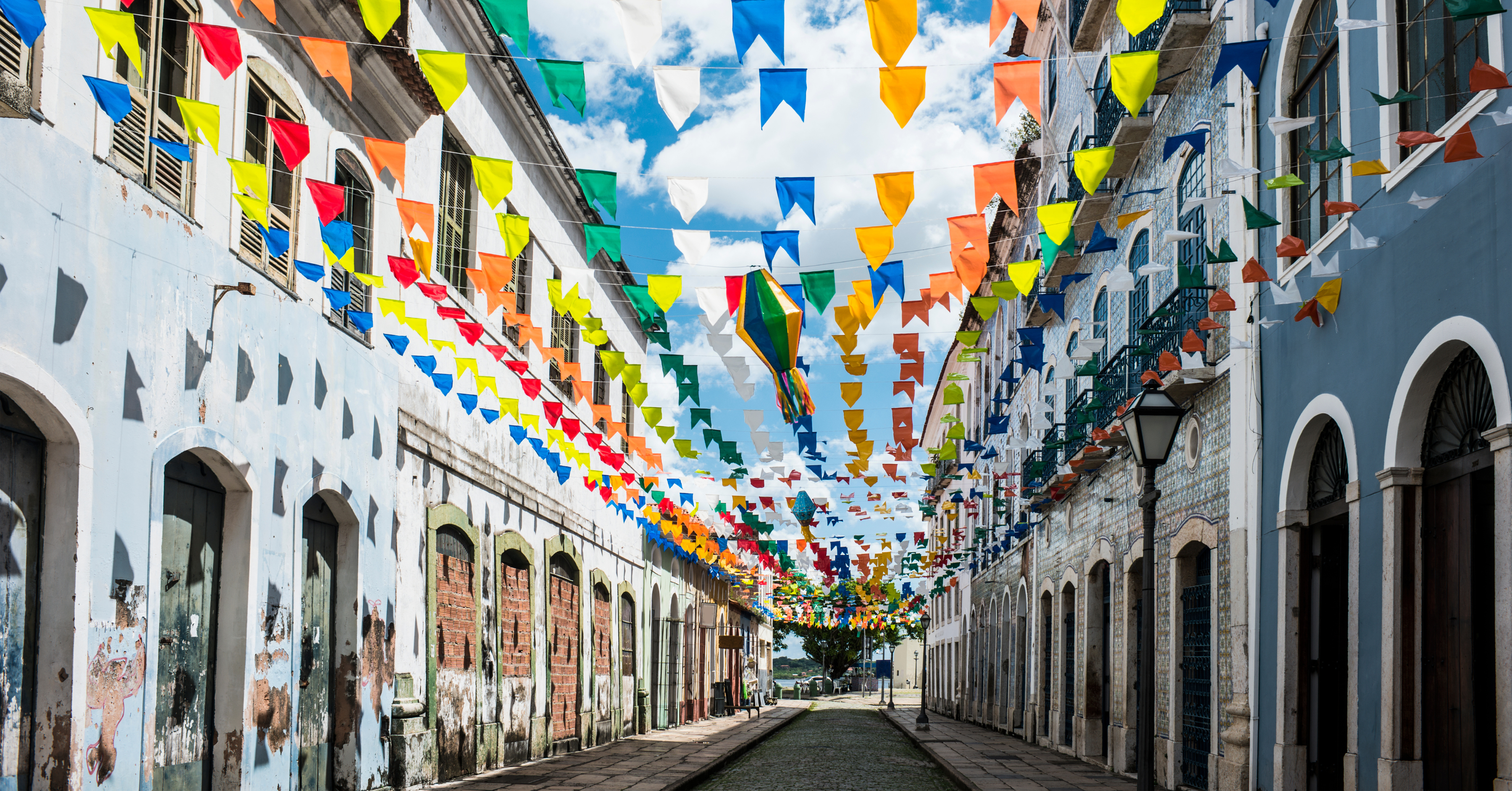 A lively street lined with colonial buildings, adorned with multicolored banners. Experiencing Brazil’s festivals and traditions is a highlight for those moving to Brazil from the US.