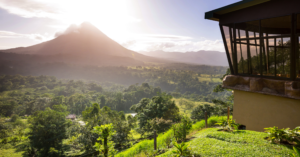 The Arenal Volcano standing majestically at sunrise, surrounded by vibrant green forests. Living near natural wonders like this is a major perk of moving to Costa Rica.