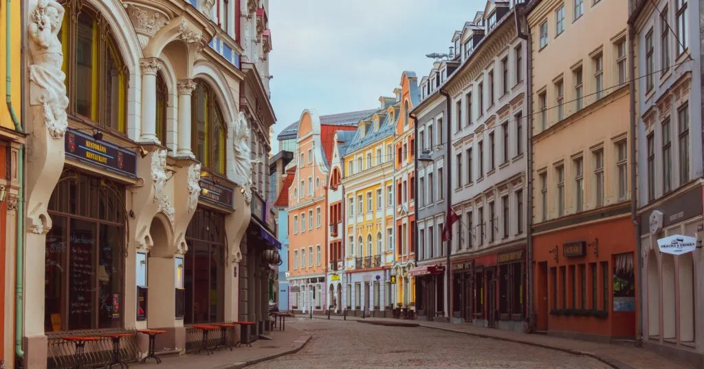 A view down a charming street in Riga’s Old Town, with colorful Art Nouveau and Baroque buildings — a picturesque example of the architectural beauty you’ll experience while living in Latvia.