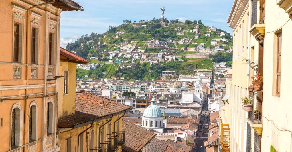 A scenic shot of Quito, Ecuador, highlighting colorful colonial buildings and the famous Panecillo hill with the Virgin Mary statue. Many Ecuador expats call this vibrant city home.