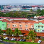 A row of pastel-colored buildings with red-tiled roofs and palm trees, representing Panama’s mix of tropical and European architectural influences. A picturesque neighborhood for expats seeking coastal living.