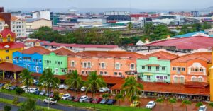 A row of pastel-colored buildings with red-tiled roofs and palm trees, representing Panama’s mix of tropical and European architectural influences. A picturesque neighborhood for expats seeking coastal living.