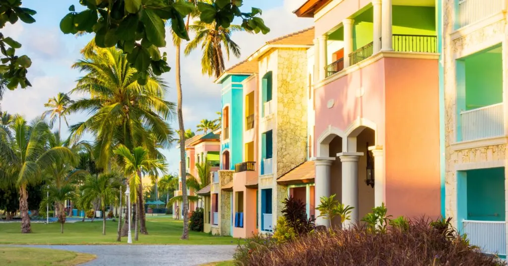 Vibrant pastel-colored apartment buildings surrounded by palm trees, reflecting the tropical charm of residential living in Dominican Republic.