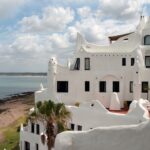 The famous Casapueblo in Uruguay, a striking white Mediterranean-style building overlooking the ocean. This cultural landmark is a must-visit for expats and tourists alike.