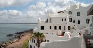 The famous Casapueblo in Uruguay, a striking white Mediterranean-style building overlooking the ocean. This cultural landmark is a must-visit for expats and tourists alike.