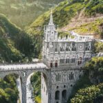 American expats walking across the Las Lajas Sanctuary bridge in southern Colombia surrounded by lush green mountains