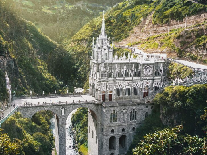 American expats walking across the Las Lajas Sanctuary bridge in southern Colombia surrounded by lush green mountains