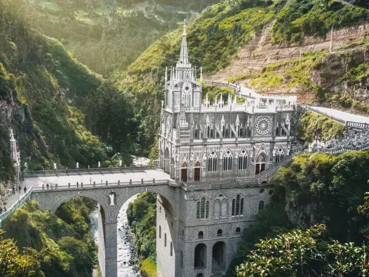 American expats walking across the Las Lajas Sanctuary bridge in southern Colombia surrounded by lush green mountains