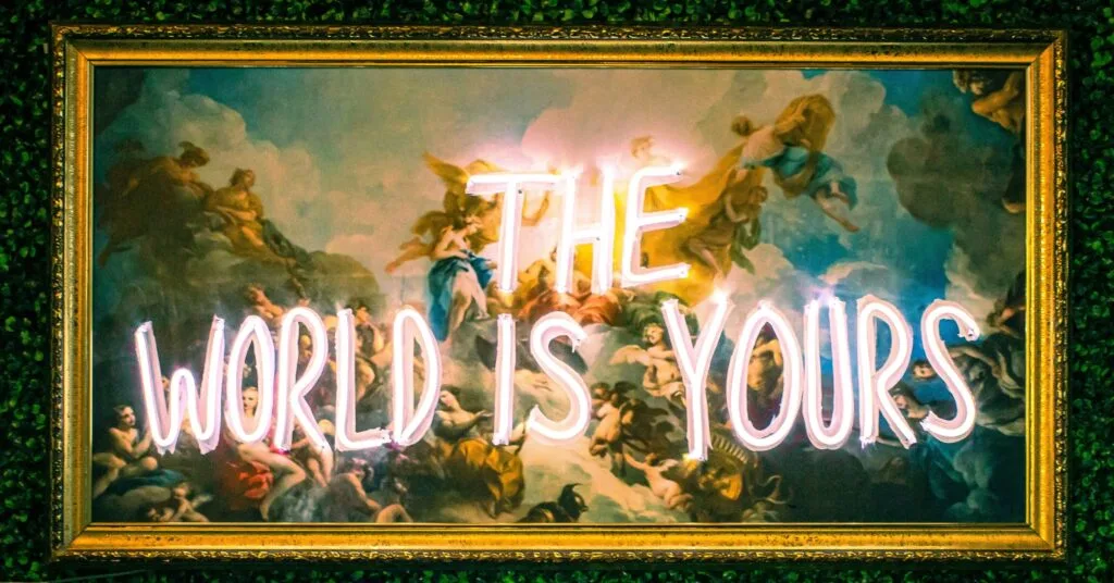 Classic-style painting with overlay of neon lights spelling “The World Is Yours,” symbolizing the endless possibilities and freedom in choosing the cheapest countries to move overseas.