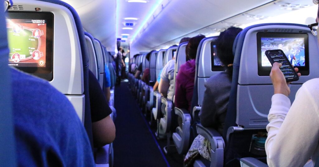 Interior of an airplane cabin filled with passengers, showing the travel experience of Americans heading to the cheapest countries to move abroad and start a new chapter.